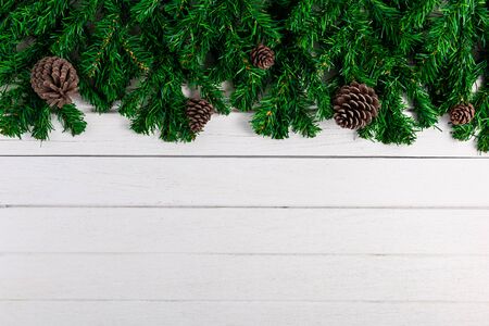 Fir branches and Pine cones on white wooden board. Christmas or New year backgroundの写真素材