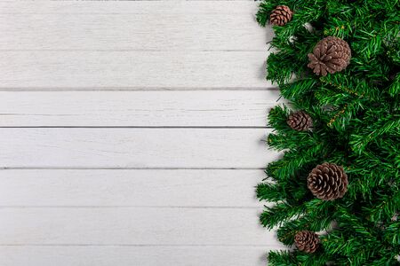 Fir branches and Pine cones on white wooden board. Christmas or New year backgroundの写真素材