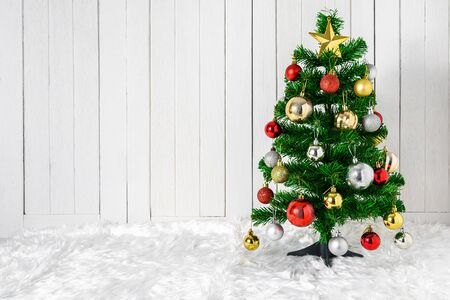 Christmas tree and ornaments on white fur and white wooden background with copy spaceの写真素材