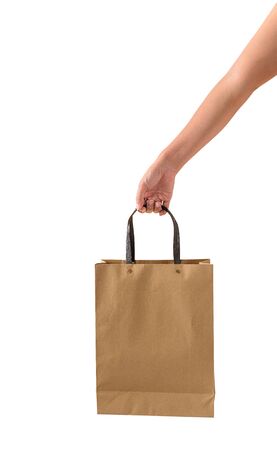 Female hand holding blank brown papaer shopping bags isolated on white background with clipping pathの写真素材