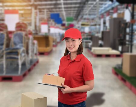 Female staff Delivering products Sign the signature on the product receipt form with parcel boxes Blurred the background of the warehouseの写真素材