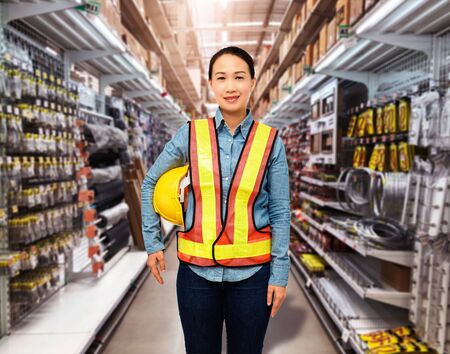 Portrait of Female staff warehouse operator with Blurred the background of Construction material on product shelf in storeの写真素材