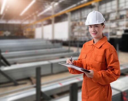 Portrait of Female staff warehouse operator with Blurred the background of Construction material on product shelf in storeの写真素材