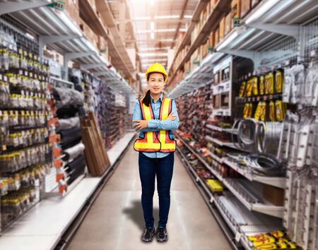Portrait of Female staff warehouse operator with Blurred the background of Construction material on product shelf in storeの写真素材