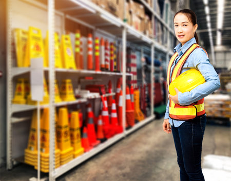 Portrait of Female staff warehouse operator with Blurred the background of safety sign on product shelf in Construction material storeの写真素材