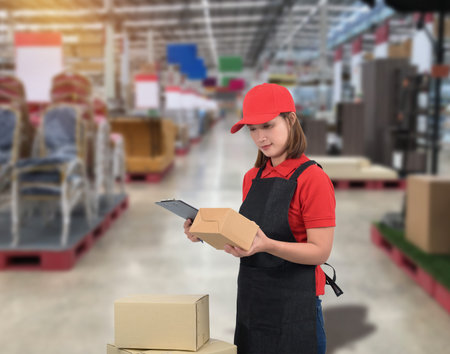 Female staff Delivering products Sign the signature on the product receipt form with parcel boxes Blurred the background of the warehouseの写真素材