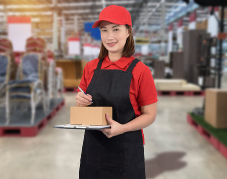 Female staff Delivering products Sign the signature on the product receipt form with parcel boxes Blurred the background of the warehouseの写真素材