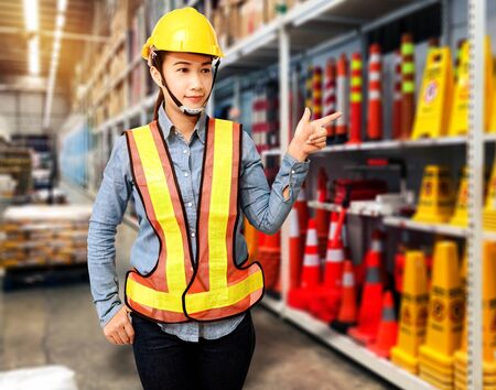 Portrait of Female staff warehouse operator with Blurred the background of safety sign on product shelf in Construction material storeの写真素材