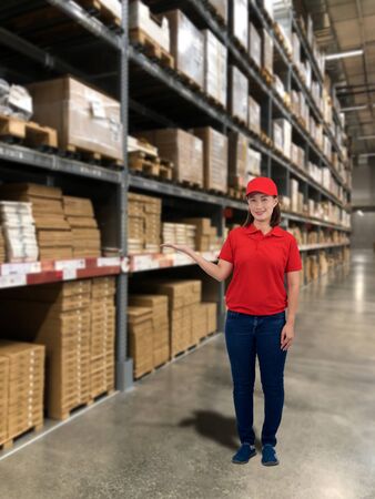 Woman operator in uniform and product shelf with Blurred the background of the warehouse storageの写真素材