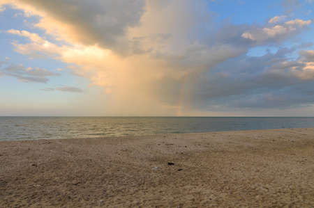 Dirty brown sand beach on sunset time, rainbowの写真素材