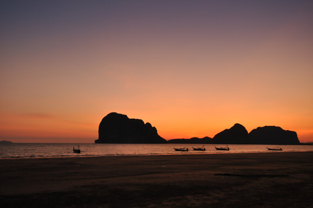 the orange sunset at the beach and blue sky with small boatの写真素材