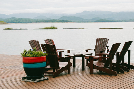 The Riverside morning view in Kanchanaburi Thailand asia with relaxing deck chairs and ferry boats.Have green mountain viewの写真素材