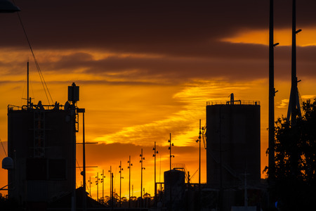A skyline of the upper east side of newzealand at sunset, with tall buildings in silhouette, outlined against the orange and blue sky.の写真素材