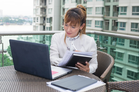 Senior asian woman working at notebook in modern officeの写真素材