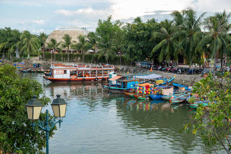 View of colorful wooden boats for tourists to make a river cruise in the port of old town Hoi An, Vietnamのeditorial素材