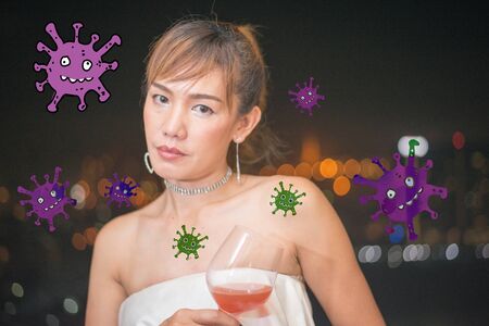 Lonely asian woman drinking makes you more vulnerable to Covid-19 and other communicable diseases and with red cocktail in white dress, background is night city have bokehの写真素材