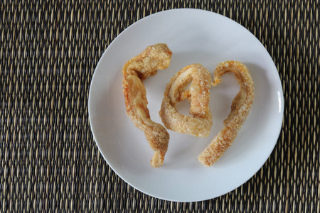 Pork rinds,pork scratchings or pork cracklings on mat sheet top view