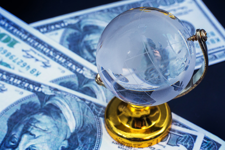 Glass globe model gold stand on money  black table backgroundの写真素材