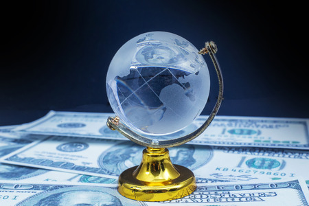Glass globe model gold stand on  money black table backgroundの写真素材