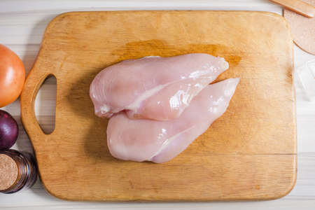Raw chicken breast with dill ready for cookingの写真素材