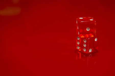 The Two Red dice on bright red glossy background.