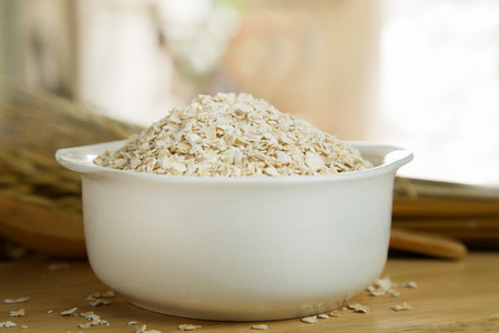 Healthy breakfast cereal oat flakes in bowl on wooden table.の写真素材