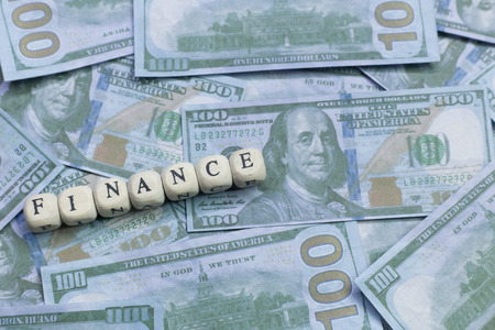 The finance word on wood brick  background banknote.の写真素材