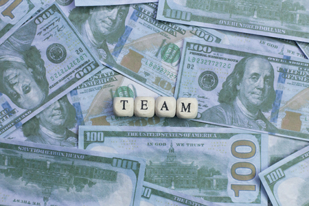 The team word on wood brick  background banknote.の写真素材