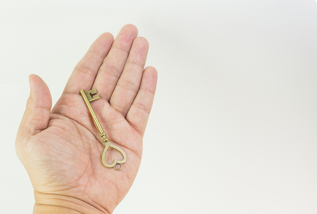 The vintage gold key in hand close up image.の写真素材