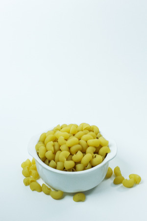 The Macaroni raw in white bowl on white background.の写真素材