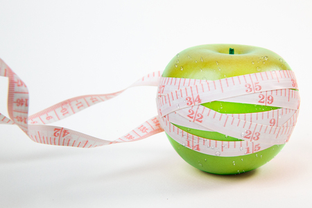A apple & measuring tape on white background.の写真素材