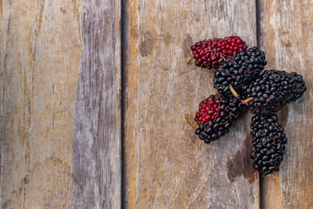 mulberry fruit in white bowl on wood table.の写真素材