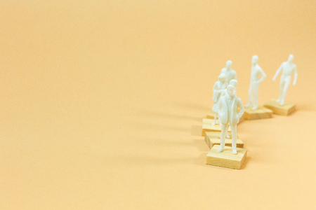 The  white  figure miniature on orange pastel for business content.の写真素材