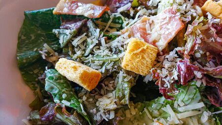 The Caesar salad in white bowl on wood table close up image.の写真素材
