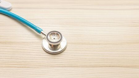 Blue stethoscopes on wood table for medical content.の写真素材