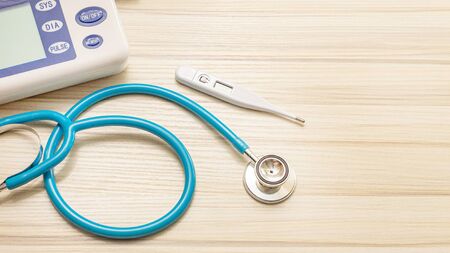 Blue stethoscopes on wood table for medical content.の写真素材