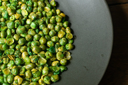 The salted peas on black Ceramic Plate close up image.