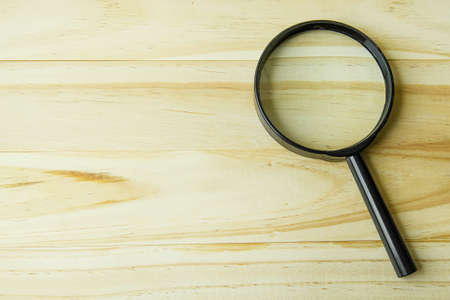 The Magnifying glass on wood background image.の写真素材