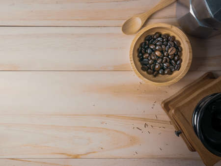 The coffee beans in  wood bowl top view on wooden table for food content.の写真素材