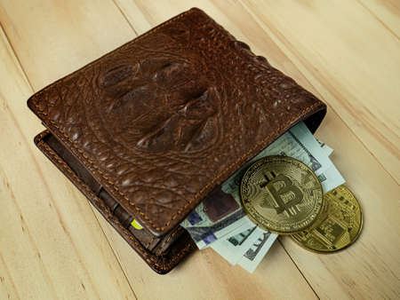 bitcoin in Crocodile leather wallet  on  wood table.の写真素材