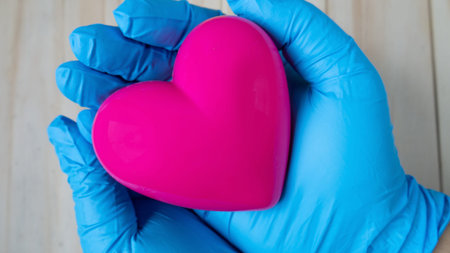 doctor hand hold pink heart image for health and medical content.