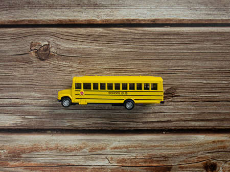 school bus on wood table for education or back to school conceptの写真素材