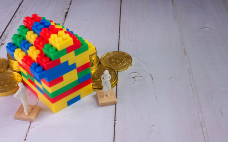 The home multicolour toy brick and gold coins for kid or property business concept