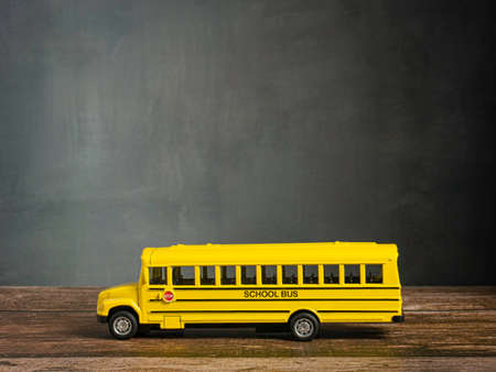 school bus on wood table for back to school or education conceptの写真素材