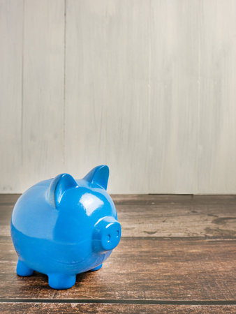 blue piggy bank on wood table for earn or saving conceptの写真素材