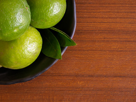 Limes are small, round, green citrus fruits from the Rutaceae family, known for their tangy flavor and versatility in culinary applications. They are closely related to lemons, oranges.の写真素材