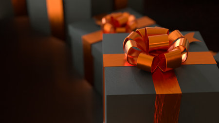 Luxury black gift boxes with shiny orange ribbons and bows, elegant holiday presents for celebration, Christmas, or special occasions, premium background with warm light.の写真素材