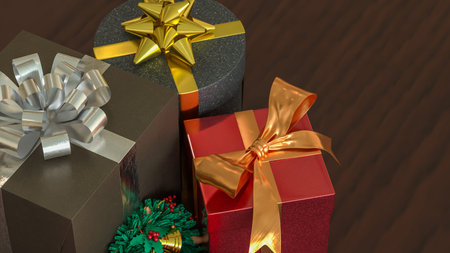 Festive Christmas gift boxes with golden ribbons and a small wreath on wooden table, creating a warm...