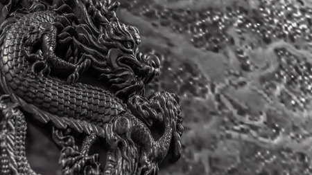 Intricate black dragon relief sculpture showcasing detailed scales and mythical elegance. Perfect for themes of Asian art, mythology, power, culture, and ornamental design.の写真素材