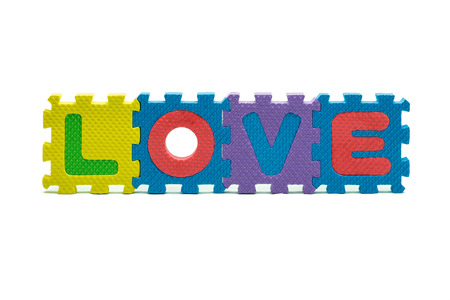 word LOVE formed with colorful foam puzzle toy isolated on white blackgroundの写真素材